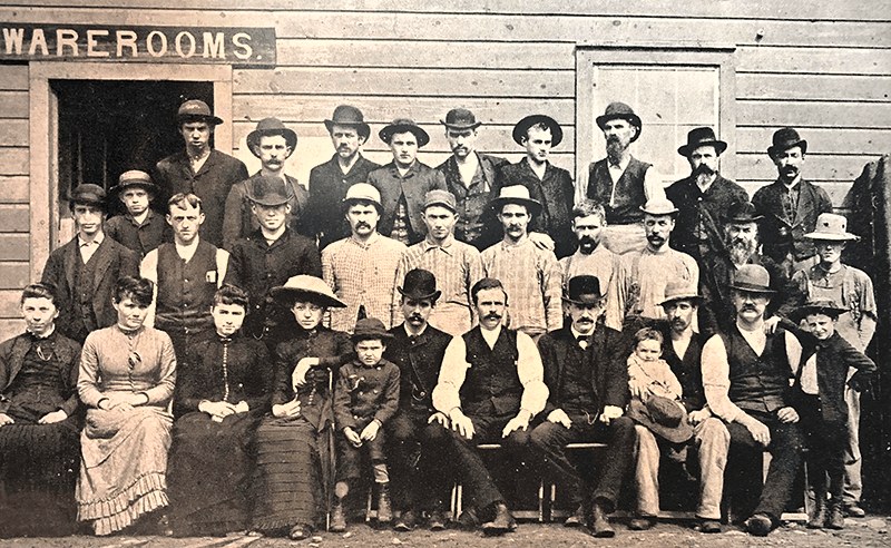 Northwestern Casket Company employees posed in front of the Warerooms sign, 1886
